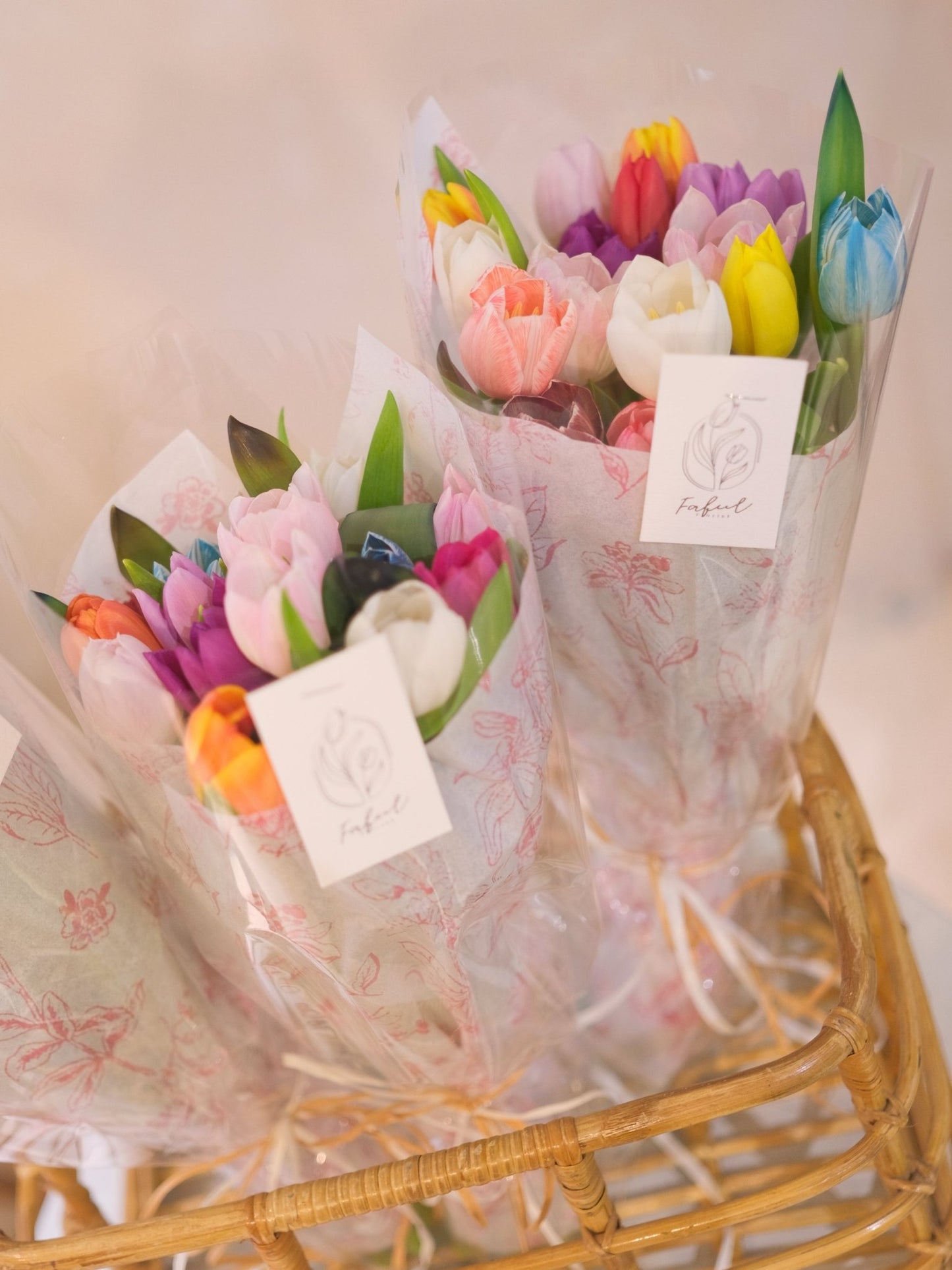 Assorted color tulip bouquets in woven baskets with clear cellophane and floral tissue by Faful Florist